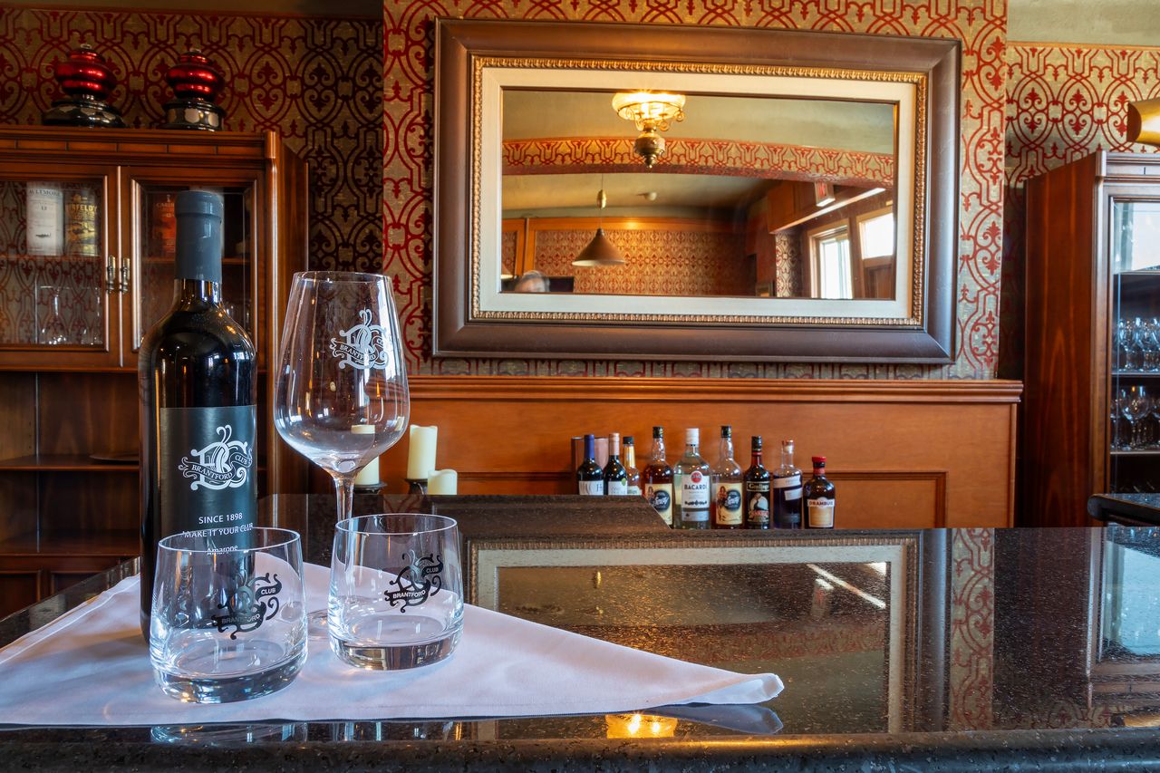 The bar at The Brantford Club with monogrammed glassware and a Since 1898 label