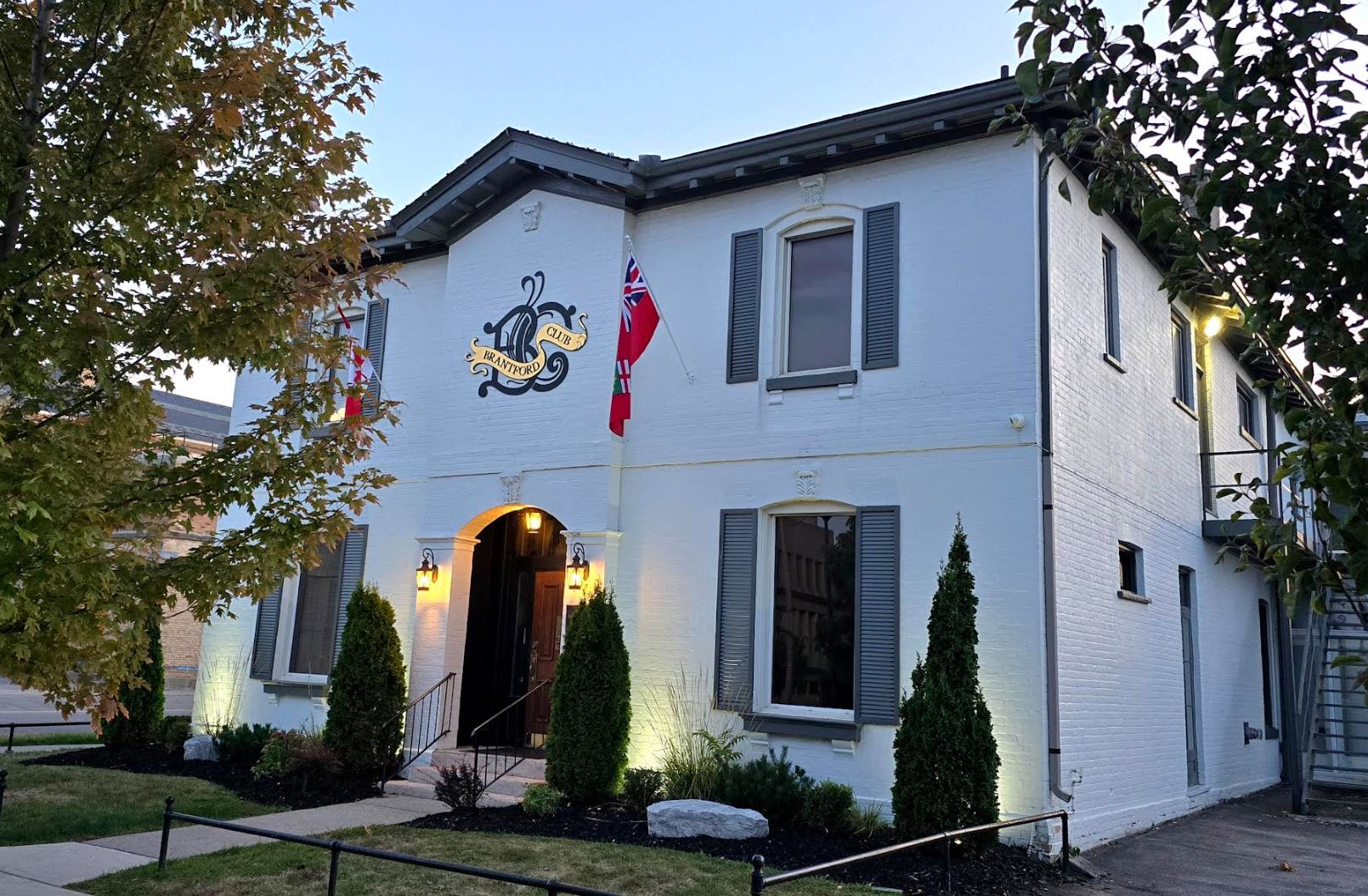 The Brantford Club house at dusk with the entrance lanterns lit
